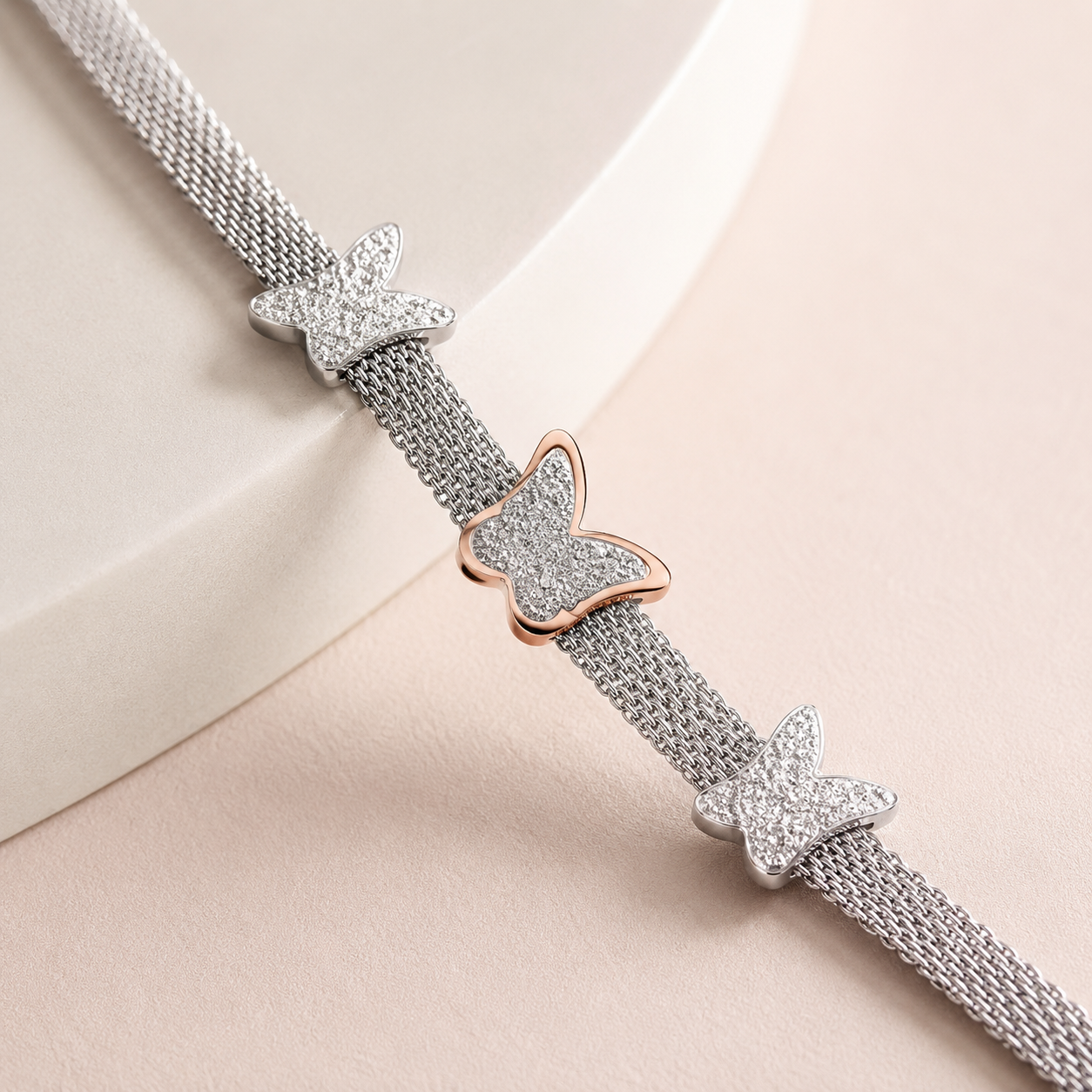 Close-up of three butterfly motifs on silver mesh bracelet