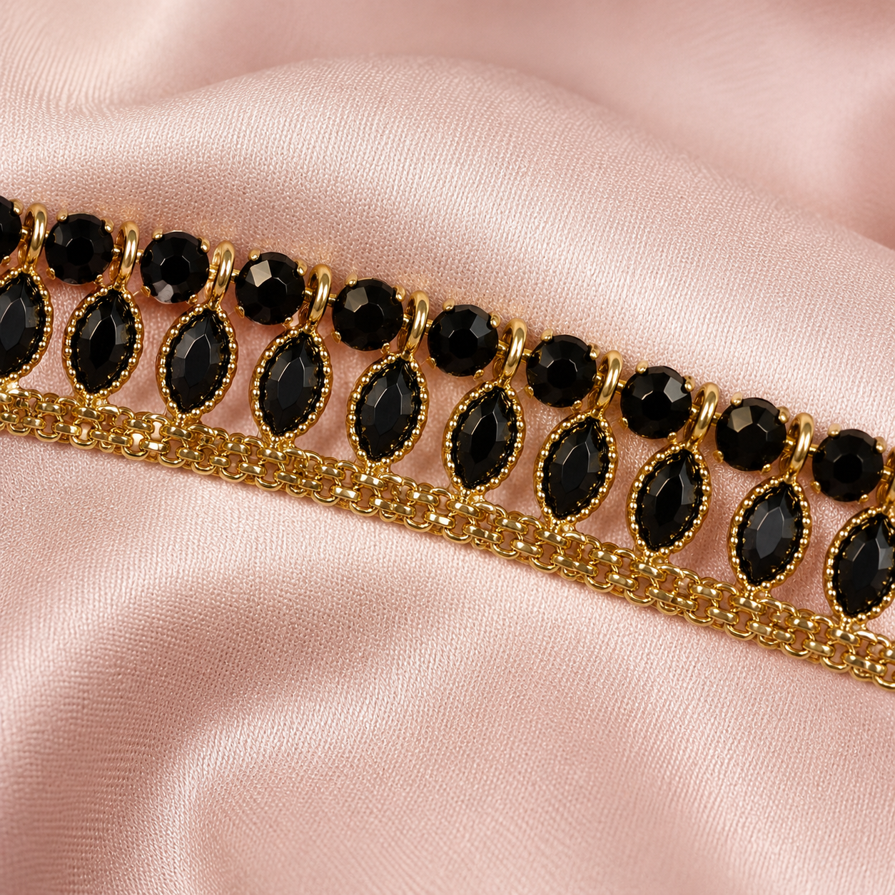 Close-up of black stones and gold-tone leaf anklet